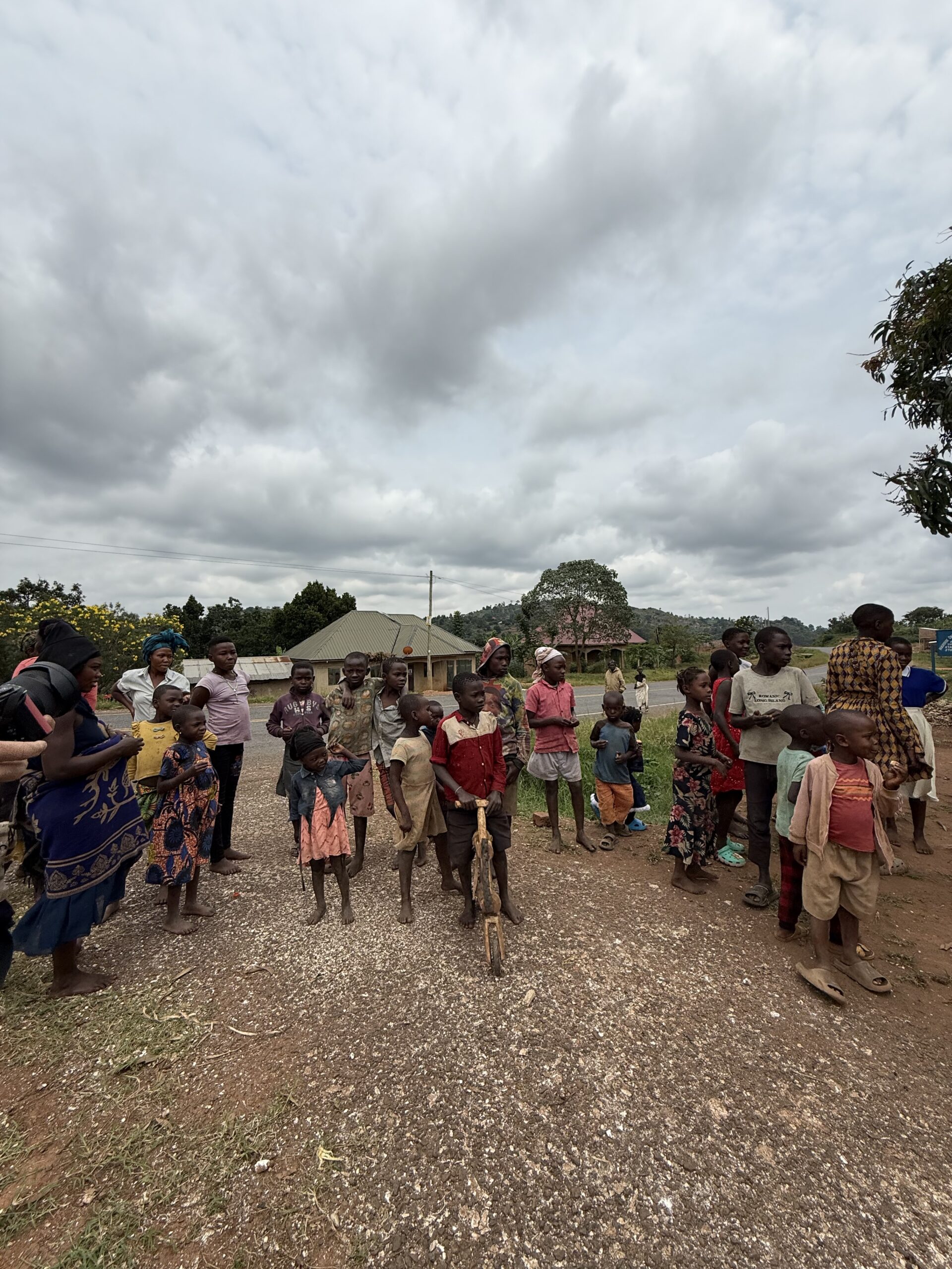 Persone della comunità locale in Uganda con bambini durante la vita quotidiana