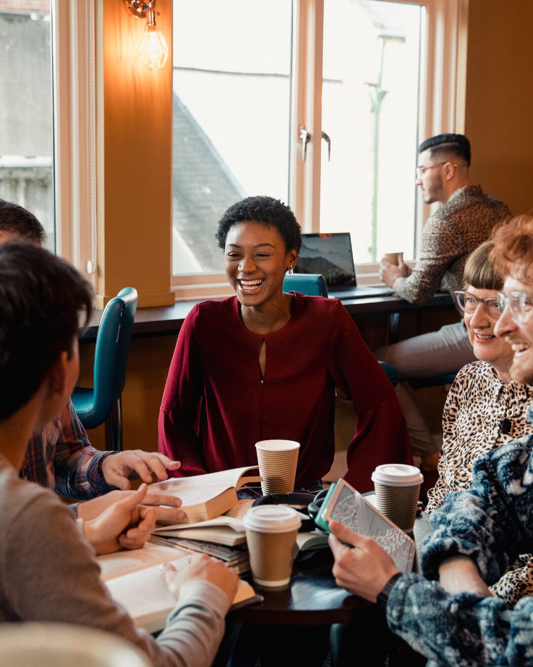 Gruppo di amici che socializza davanti a un caffè e crea nuove connessioni