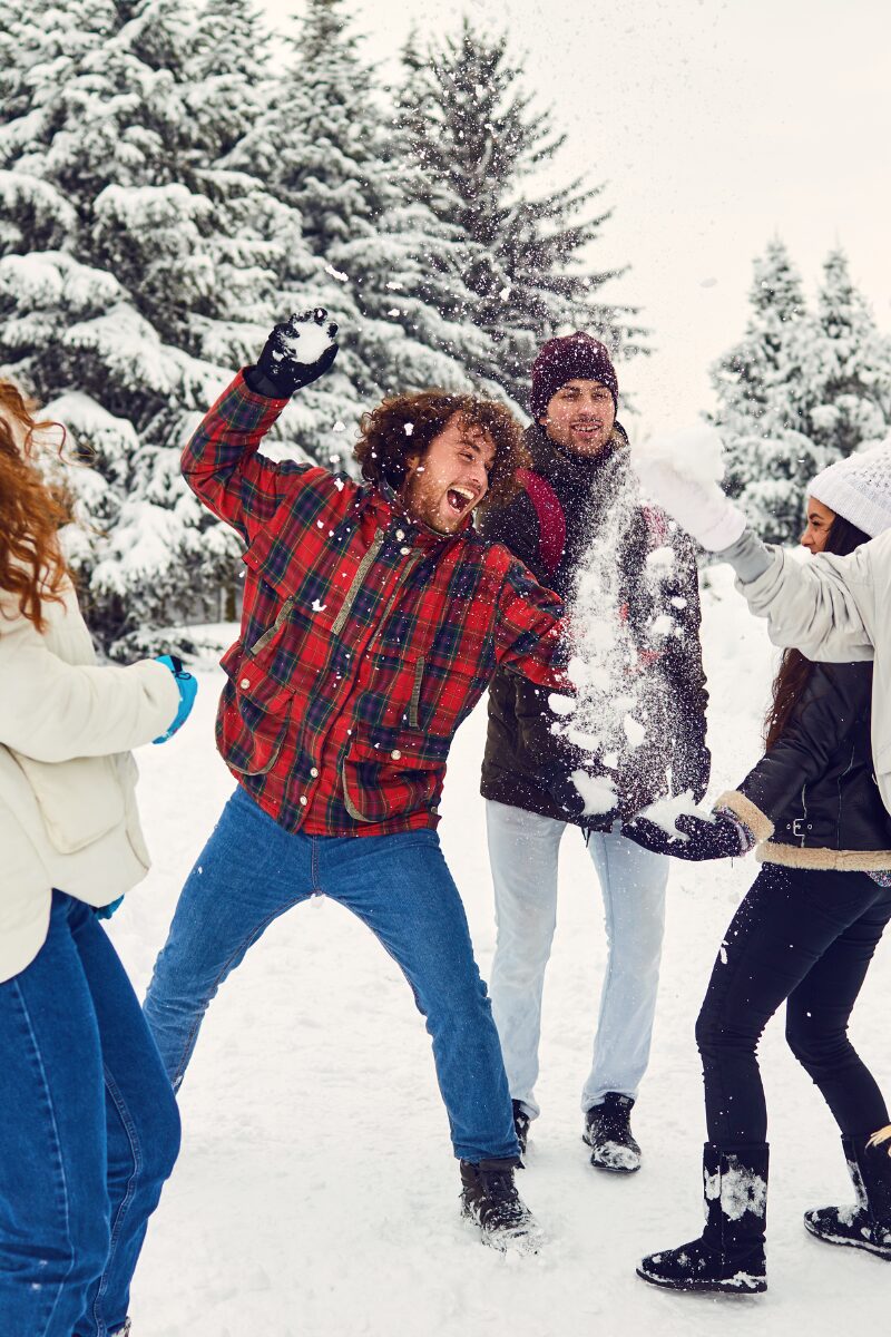 Amici che si lanciano palle di neve durante un momento di gioco